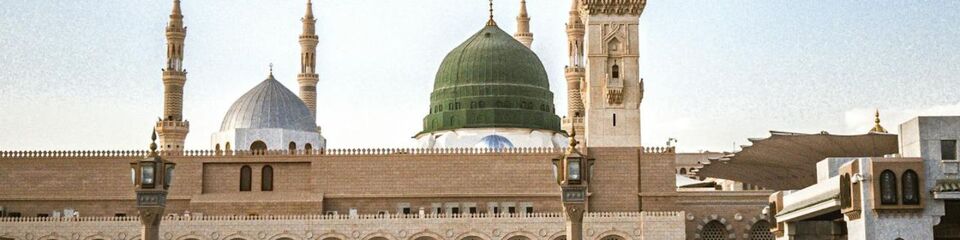 Vista di un elegante palazzo bianco in Arabia Saudita, circondato da un cielo azzurro e dettagli architettonici tradizionali. Arabia saudita_websim3