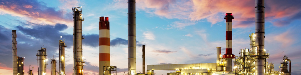 La città pulsa di energia, con ciminiere e serbatoi all’orizzonte.