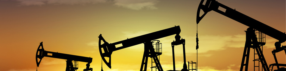 Petrolio_websim9 Un paesaggio urbano segnato da torri di perforazione e impianti di raffinazione.