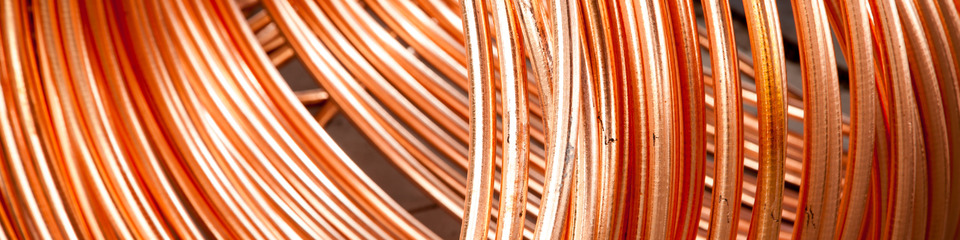 rame_websim_2 Fili di rame lucenti arrotolati: Primo piano di fili di rame brillanti e avvolti, pronti per l'uso in impianti elettrici.
