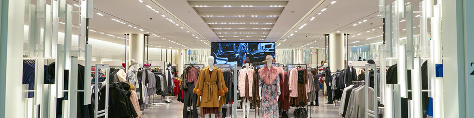 Interno di supermercato con prodotti sugli scaffali: Ampia corsia di supermercato con espositori pieni di prodotti vari.