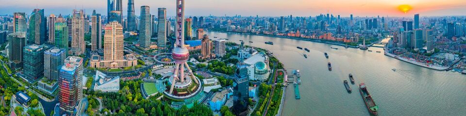 shanghai websim 2 Shanghai di notte illuminata: Panorama notturno della città con edifici iconici illuminati e riflessi di luci colorate sul fiume