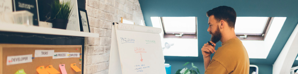 Ufficio open space con piccoli gruppi di lavoro impegnati in brainstorming e sviluppo di nuovi prodotti.