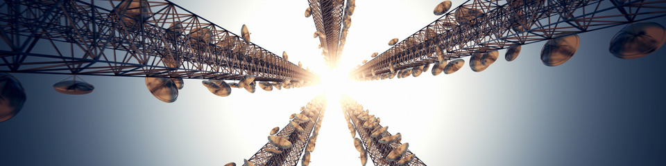 Telecomunicazioni_websim1 Strutture metalliche alte per la trasmissione di segnali, immerse in un cielo dai colori caldi.