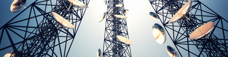 Telecomunicazioni_websim6 Diverse antenne di trasmissione installate su tralicci, con nuvole scure sullo sfondo.