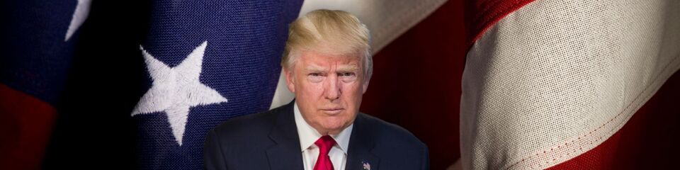 trump_websim1 Immagine di Trump in primo piano con aria di sfida e sfondo con la bandiera quotidiana