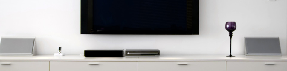 TV accesa al centro di un salotto moderno, con immagine chiara sullo schermo.