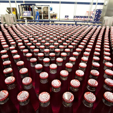 Bottigliette campari Una serie di bottigliette Campari ordinate con precisione, simbolo della cura artigianale e dell’inconfondibile rosso del brand.