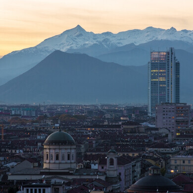 Veduta aerea di tramonto di Torino Vista dall’alto di Torino con la cupola della Chiesa di San Massimo, il grattacielo Grattacielo Intesa Sanpaolo e le Alpi innevate sullo sfondo.