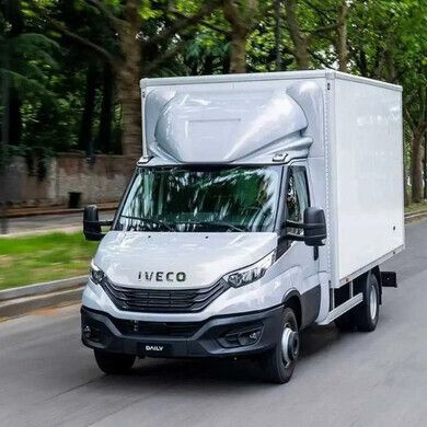 Camion Iveco bianco in movimento su strada.