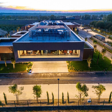 Facciata della sede di Pharmanutra illuminata, evidenziando l’architettura dell’edificio