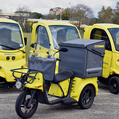 Veicoli della flotta aziendale Poste Italiane parcheggiati in area logistica, pronti per le operazioni di consegna.