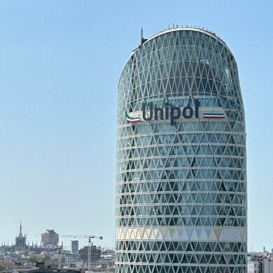 Veduta diurna della Torre Unipol a Milano, sede principale, con facciata moderna e vetri riflettenti.