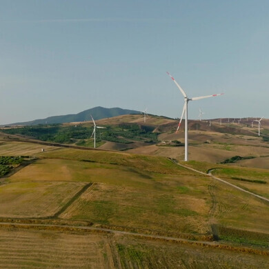 Parco eolico in paesaggio verdeggiante italiano