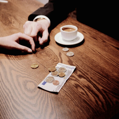 Acquisto di caffè con euro Primo piano di mani che pagano un caffè con banconote e monete in euro, rappresentando un acquisto quotidiano in contanti.