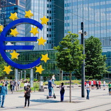 Simbolo dell'euro, Francoforte, Germania Grande scultura del simbolo dell’Euro davanti alla Banca Centrale Europea a Francoforte, Germania, con persone visibili.