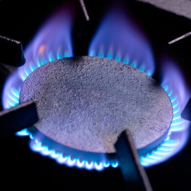 Piano cottura a gas con fiamma blu Fornello acceso con fiamma blu uniforme, simbolo di cucina domestica sicura e funzionamento corretto del gas.