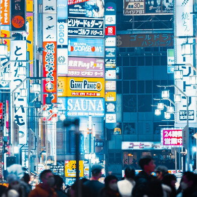 Persone che attraversano la strada di notte all’ingresso di Kabukicho a Tokyo.