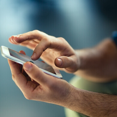 Primo piano di uno smartphone acceso, con schermo visibile e in uso.