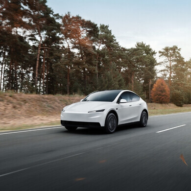 Scatto dell’auto Tesla Model Y Standard bianca da un’angolazione tre quarti, mostrando cofano e fiancata.