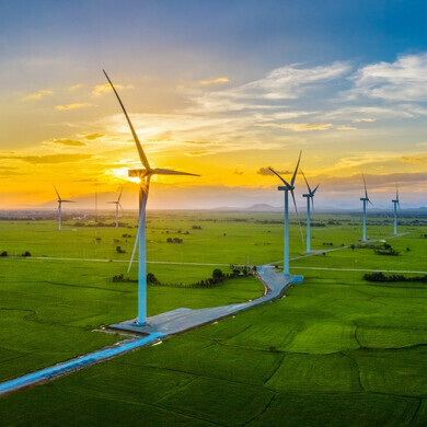 Pale eoliche all'alba Pale eoliche in un paesaggio aperto, illuminate dai primi raggi del sole mattutino
