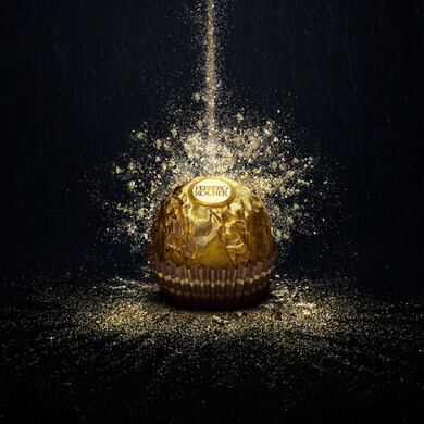 Singolo cioccolatino Ferrero Rocher posizionato su sfondo nero elegante