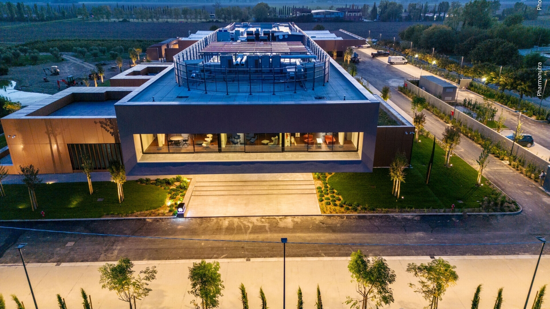 Illuminazione sede Pharmanutra Facciata della sede di Pharmanutra illuminata, evidenziando l’architettura dell’edificio