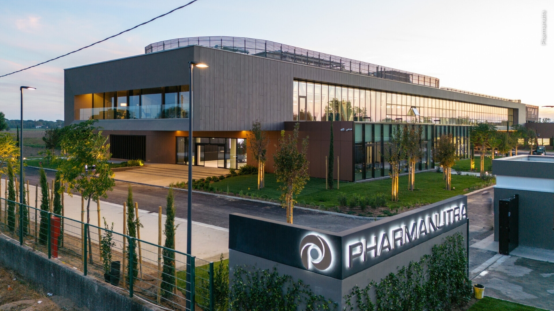 Vista dell’ingresso principale di Pharmanutra, con porte e logo visibili.