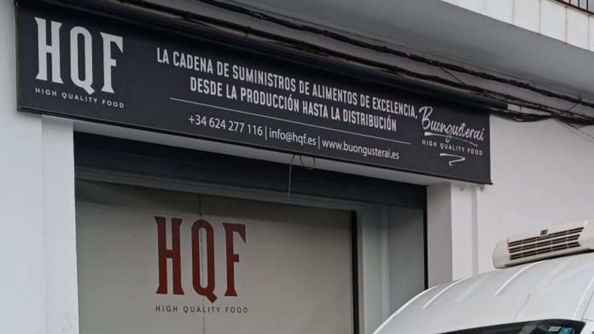 Ingresso del magazzino HQF, con area di carico e segnaletica aziendale.