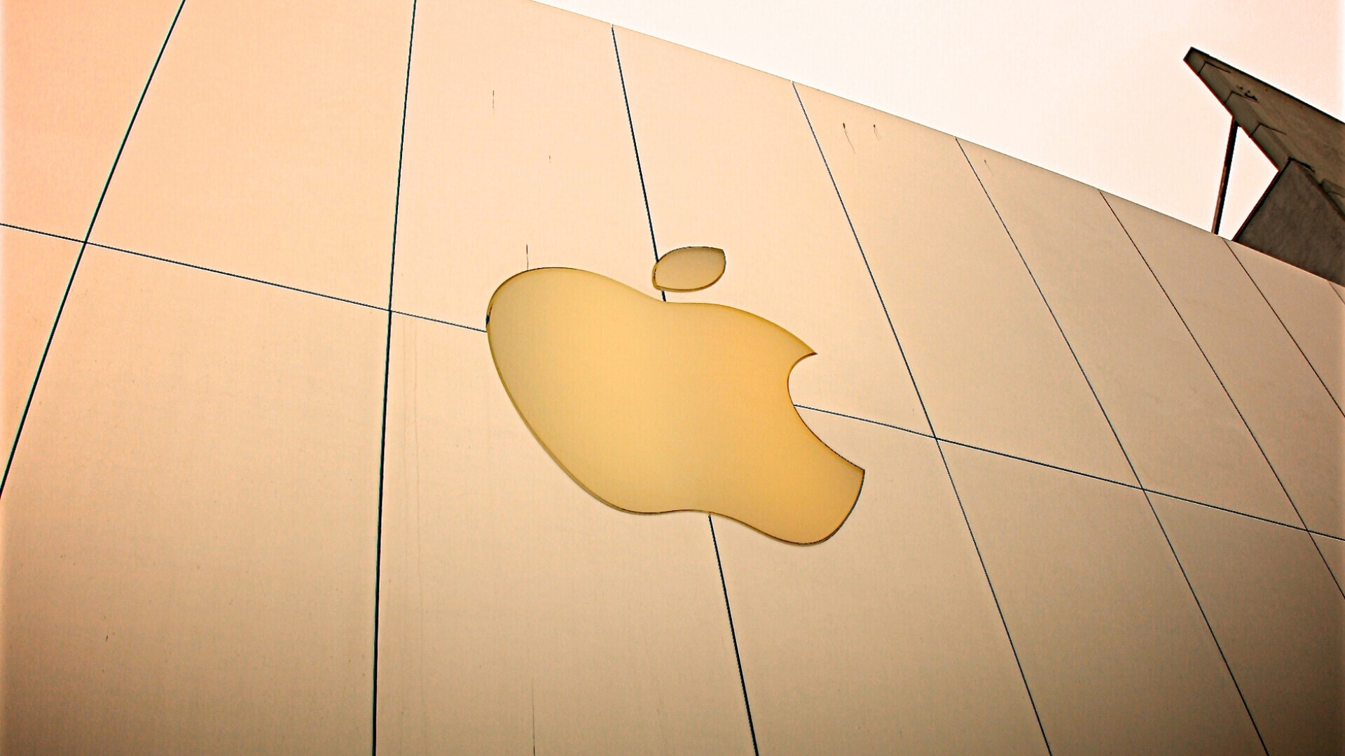 Logo apple oro su una facciata Logo Apple dorato applicato sulla facciata di un edificio