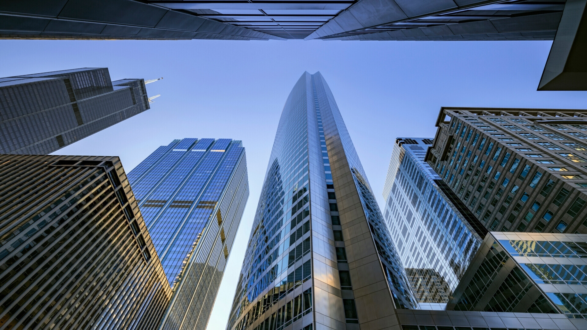 Guardando verso l’alto edifici per uffici moderni in una giornata limpida e soleggiata 2 Edificio per uffici moderno nel cuore del quartiere finanziario di Chicago, con facciate in vetro e architettura contemporanea.