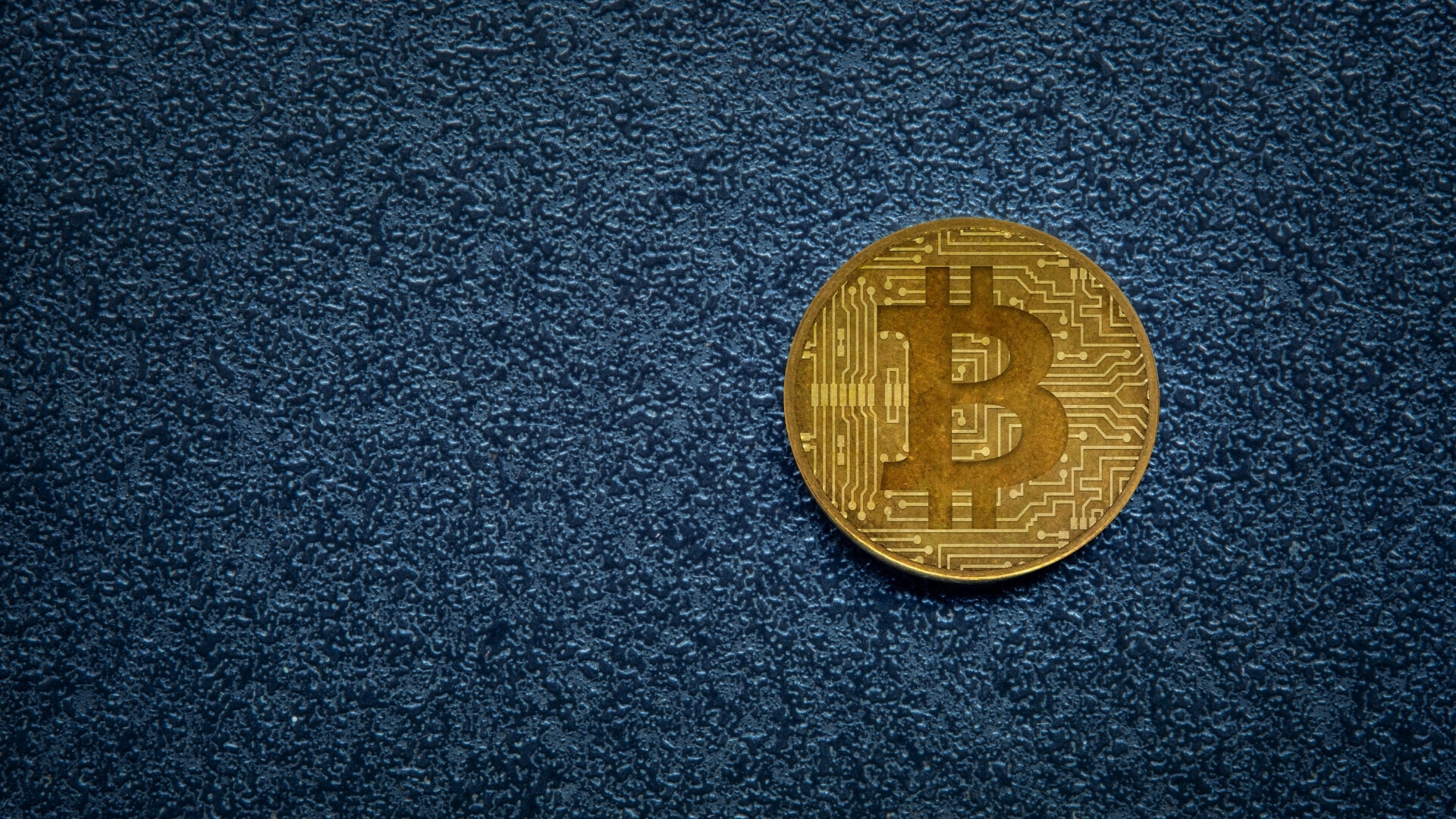 Moneta di Bitcoin su sfondo scuro Moneta di Bitcoin su sfondo scuro e increspato