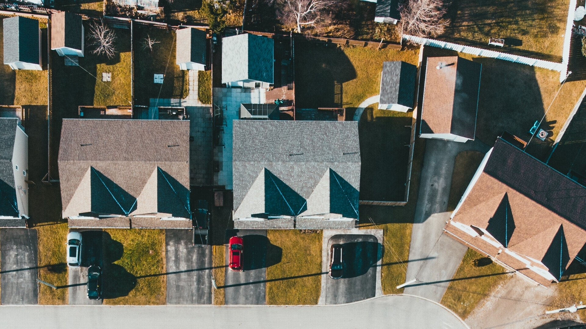 Vista aerea di quattro villette Quattro villette allineate viste dall’alto, con piccoli giardini e cortili