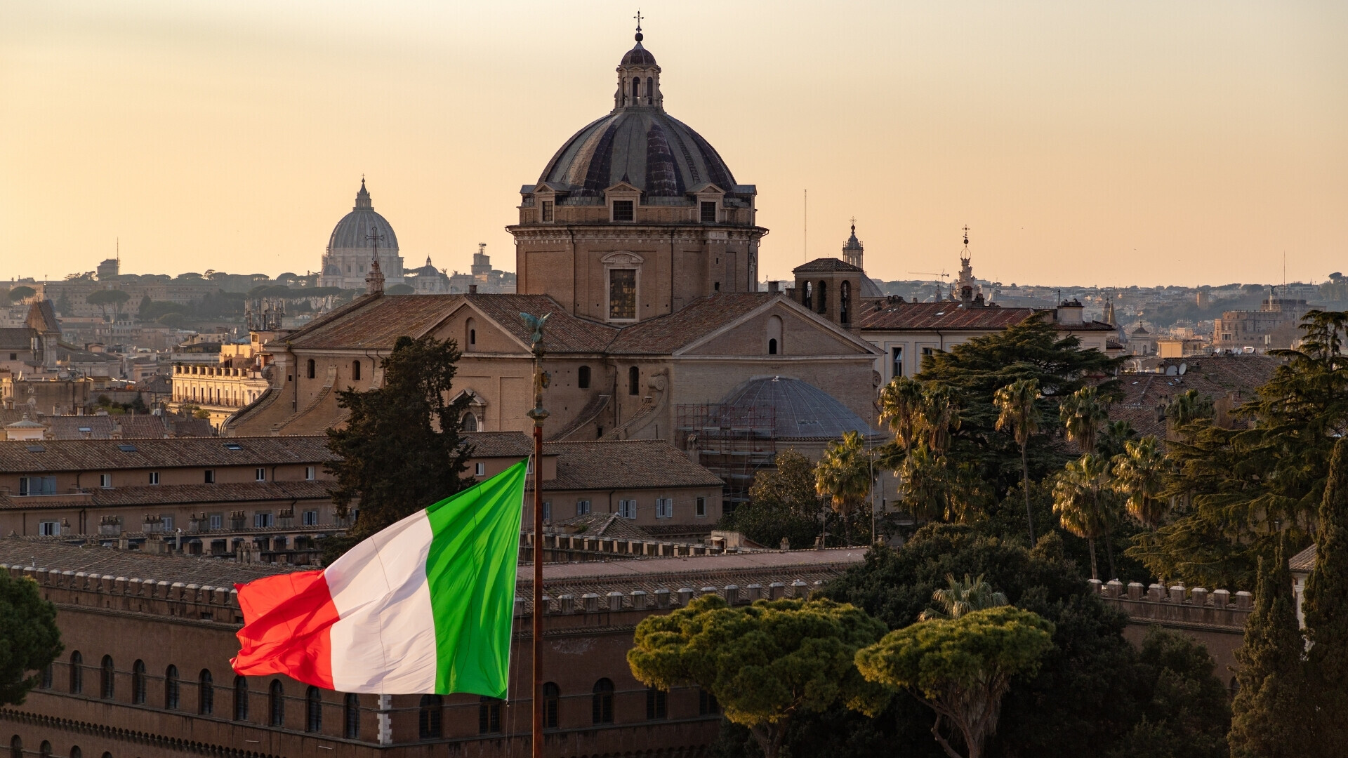 Bandiera italiana e vista di una città italiana Bandiera italiana sventolante con vista di edifici e città sullo sfondo