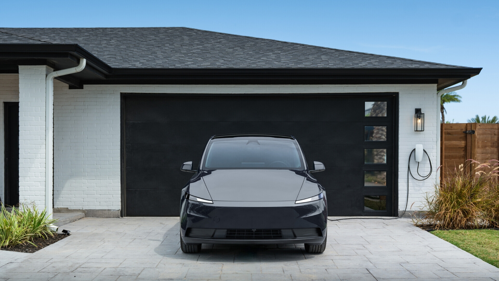 Immagine laterale di una Tesla Model Y Standard grigia, con dettagli della carrozzeria visibili.