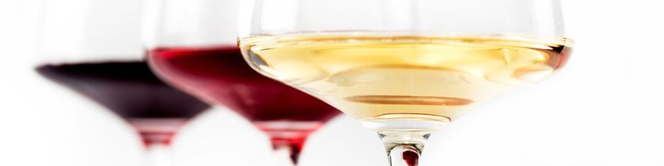 ino rosso versato in un bicchiere, circondato da uva fresca